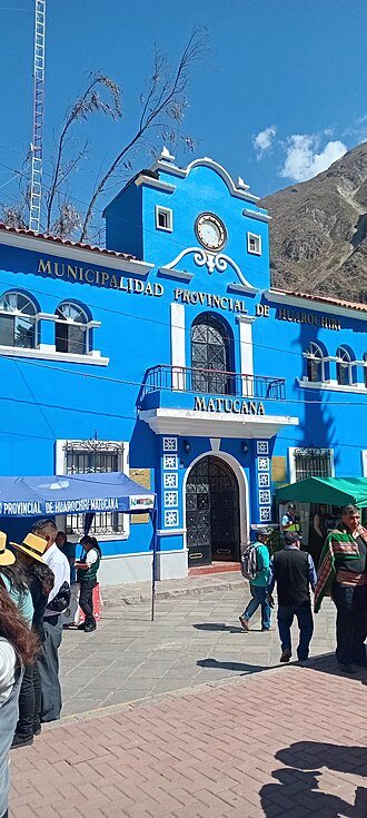 Traditioneel Peruaans gebouw met kleurrijke architectuur tegen bergachtige achtergrond.