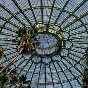 Koninklijke Serres van Laken met glazen koepels en groene omgeving.