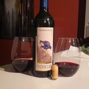 Chambourcin wijngaard met rijpe druiventrossen en groene bladeren in zonlicht.