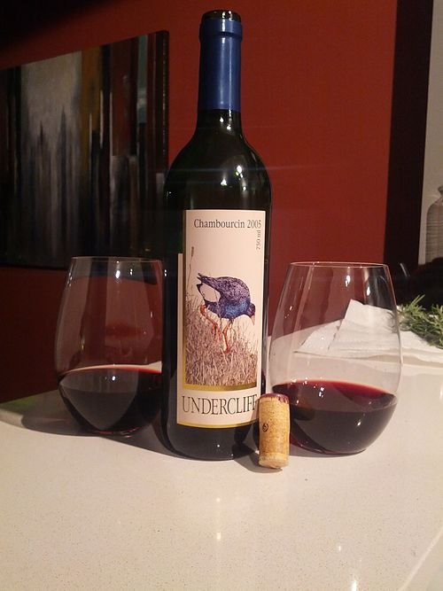 Chambourcin wijngaard met rijpe druiventrossen en groene bladeren in zonlicht.