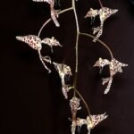 Gongora arcuata orchidee bloem op groen blad met paarse en gele tinten.