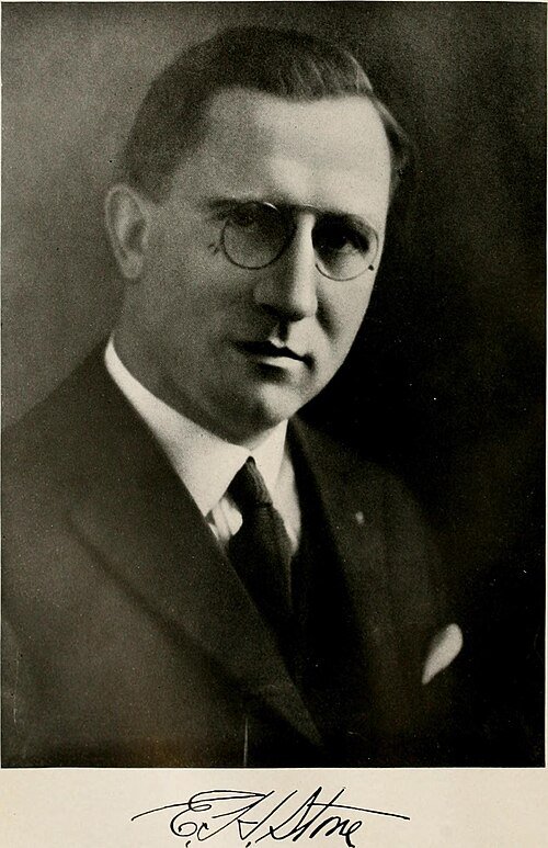 Moderne Tom Carruth eettafel met glazen blad en zwarte metalen poten.