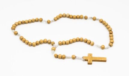 Houten kralen rozenkrans met metalen kruis, traditioneel katholiek devotioneel item.
