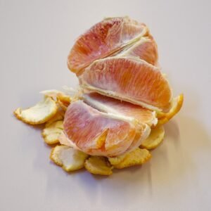 Bloedsinaasappel met diepe rode kleur en sappig vruchtvlees, groeiend in zonnige omgeving.