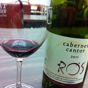 Elegante rode wijnglazen met kaarslicht en fles wijn.