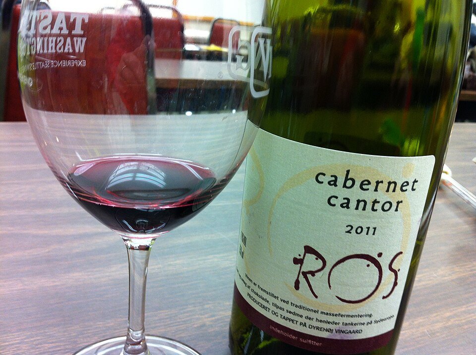 Elegante rode wijnglazen met kaarslicht en fles wijn.