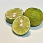 Citrus sudachi fruit op houten oppervlak, groen en rond, met getextureerde schil.
