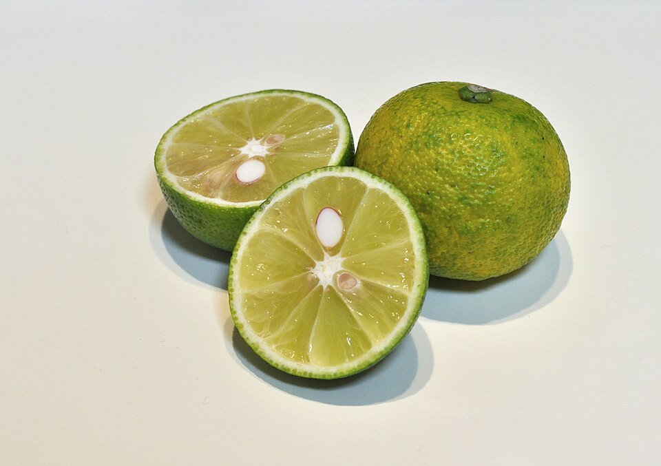 Citrus sudachi fruit op houten oppervlak, groen en rond, met getextureerde schil.