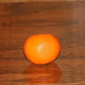 Rijpe clementine op houten tafel, met groen blad en schil.