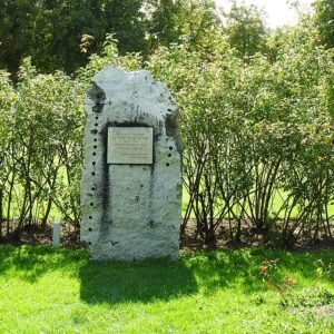 Gedenksteen voor Rudolf Geschwind in schaduwrijke setting.