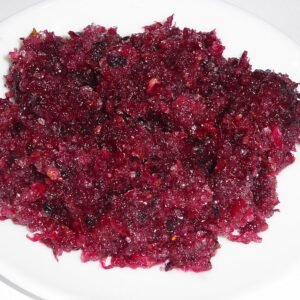 Dark pink homemade Gulkand in glass jar with fresh rose petals.