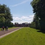 Middeleeuws kasteel met torentjes en ophaalbrug tegen groene heuvels.