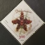 Grammatophyllum speciosum orchidee postzegel uit Indonesië 2017 met levendige gele en oranje bloemen.