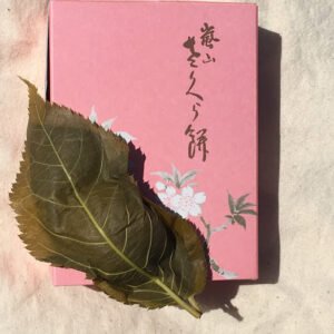 Roze Sakuramochi rijstcake met kersenbloesem op de top.